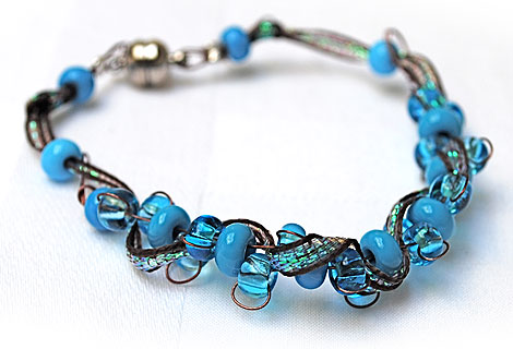 Joanne ribbon and wire threaded bracelet - Beautiful combination of woven wire, iridescent maroon ribbon and blue beads make up this sparkling necklace. Fastened with a silver plated screw clasp. Matching bracelet and earrings available.
