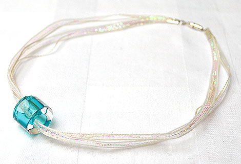 Beth turquoise glass pendant - Simple and chic circular glass pendant double threaded onto white iridescent ribbon. Screw clasp.