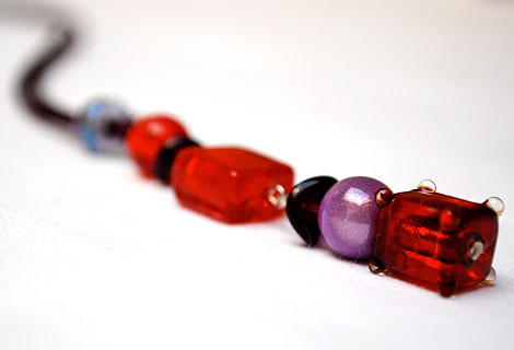 Harlequin burgundy/red long drop pendant - Funky and bright, this pendant is designed to be worn long, but can be adjusted in length using a sliding bead. Beautiful rich red and burgundy beads hang from silky cord.