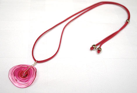 Catherine pink disc pendant - An unusual curved glass disc suspended by wire from a pink suede cord. Length is adjustable using a sliding bead.